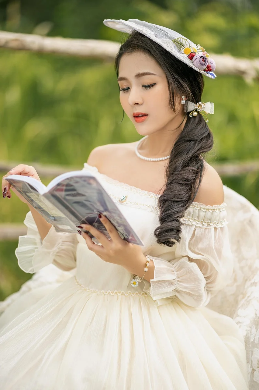 Gái xinh Việt Nam mặc váy trắng vintage đội mũ hoa đọc sách trong vườn