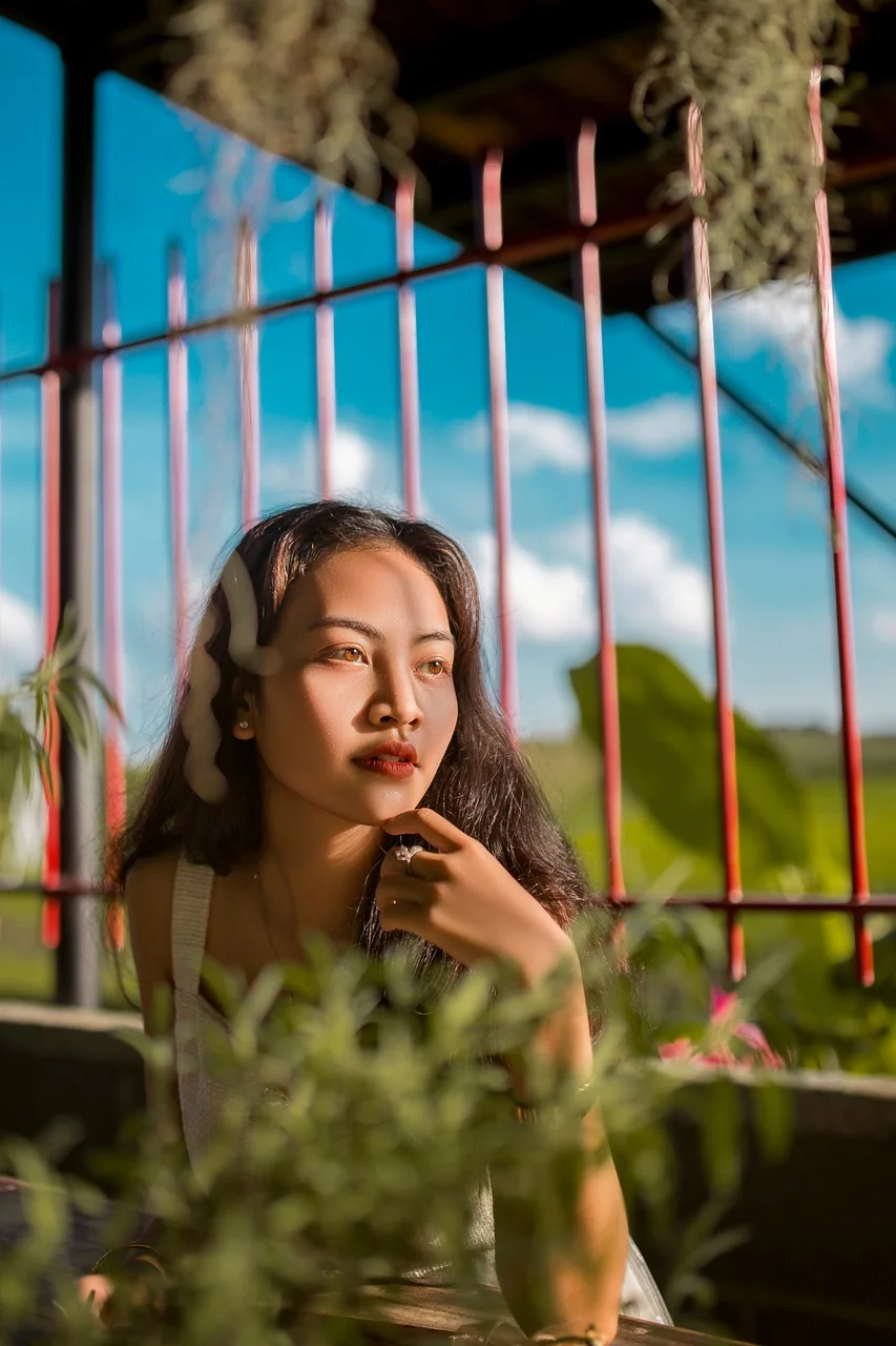 Gái xinh Việt Nam tóc dài ngồi quán cà phê ngoài trời dưới ánh nắng chiều vàng